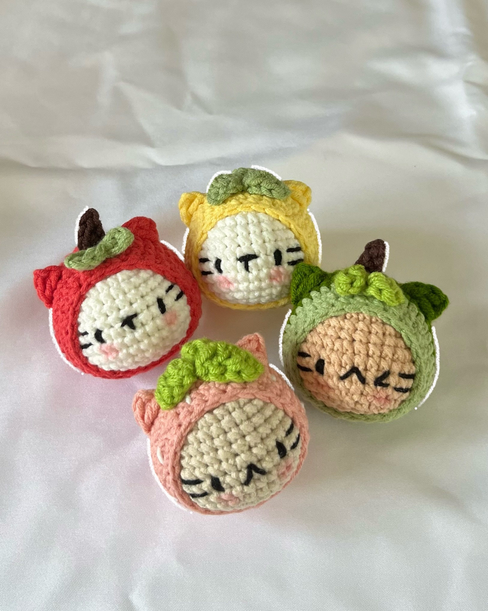 crochet cats cosplaying as fruits